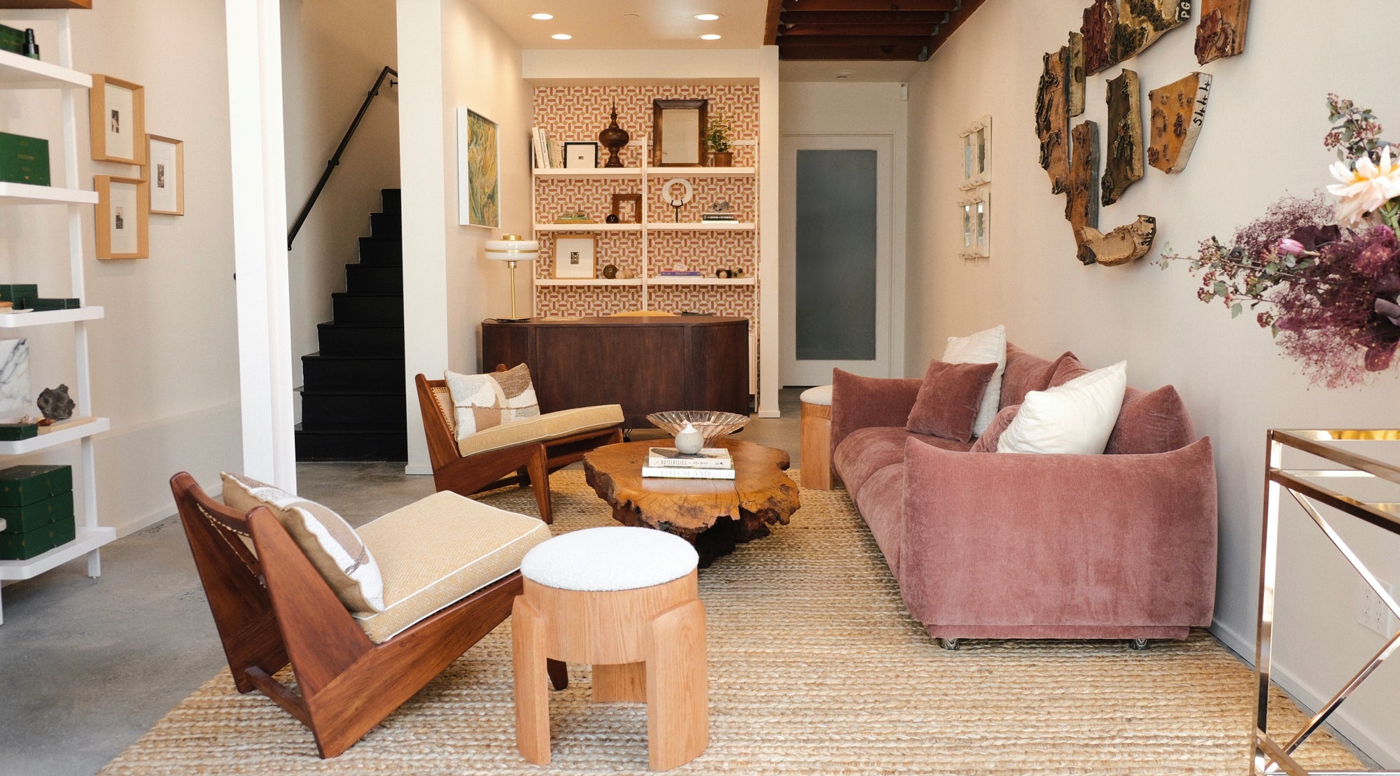 Wildling living room with a pink sofa, wooden chairs, and decorative wall art.